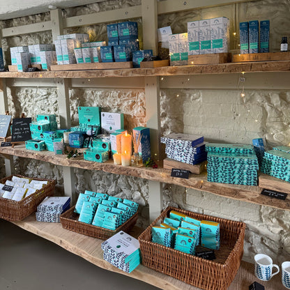 Shelves with turquoise Summerdown chocolate boxes and baskets in a rustic setting