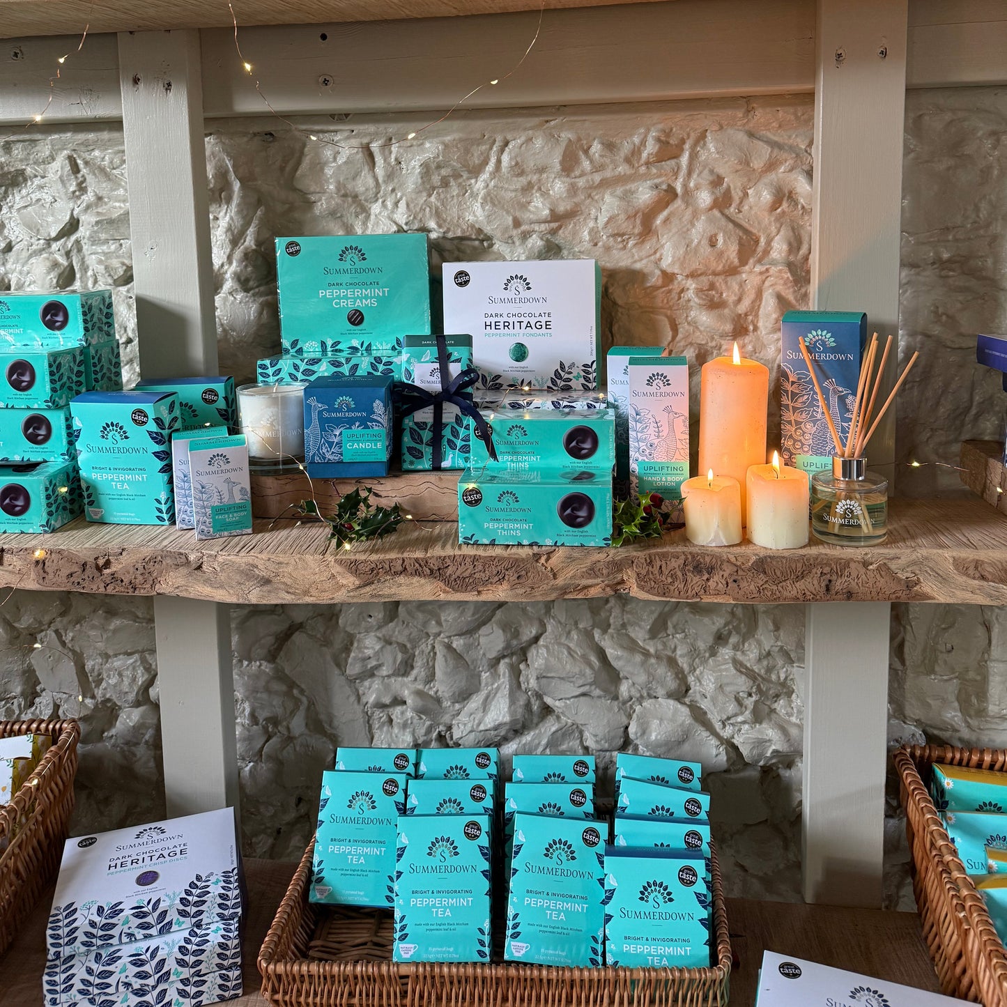 Display of Summerdown chocolates and tea boxes with white labels on a stone wall background